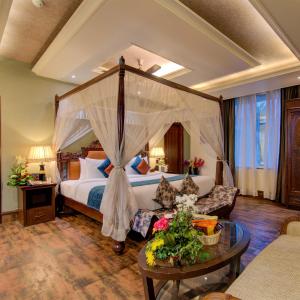um quarto de hotel com uma cama e um sofá em Godwin Goa em Candolim