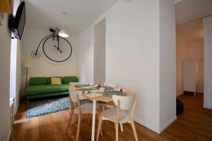 a dining room with a table and a green couch at Lisbon Intendente Terrace Apartment with BBQ in Lisbon