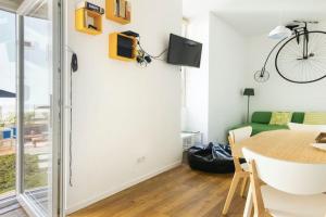 a living room with a table and a bike on the wall at Lisbon Intendente Terrace Apartment with BBQ in Lisbon