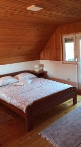 a bedroom with a large bed in a wooden room at Konak Pahulja TARA in Bajina Bašta