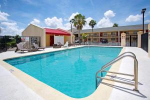 a large swimming pool with chairs and a hotel at Super 8 by Wyndham Orlando International Drive in Orlando
