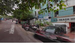 une voiture garée sur le côté d'une rue avec des motos dans l'établissement Nandita S Beach Bay Rest House By WB Inn, à Visakhapatnam