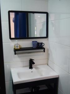 uma casa de banho com um lavatório e um espelho na parede em Cửa Biển Homestay em Hai Phong