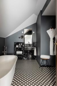 y baño con bañera blanca y lavamanos. en TÓTEM Madrid, a Small Luxury Hotel of the World, en Madrid