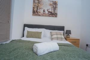 a bed with a white pillow on top of it at The Highfield Villa, 5 bedrooms, Northampton Centre, Sleeps 10 in Kingsthorpe