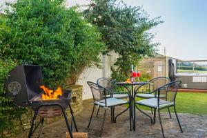 a patio with a table and chairs and a fire place at CROYDE VILLA SUNSEA 6 Bedrooms in Croyde