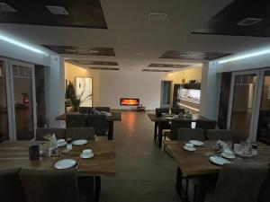 a restaurant with wooden tables and chairs and a fireplace at Die 1A Pension in Welsau