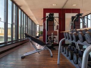 een fitnessruimte met een rij loopbanden in een kamer bij Mövenpick Hotel Frankfurt City Messe in Frankfurt am Main