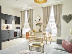 un soggiorno con divano e tavolo di Curb Properties - Super 2 Bed Apartment 5 Min From Town Centre a Cheltenham