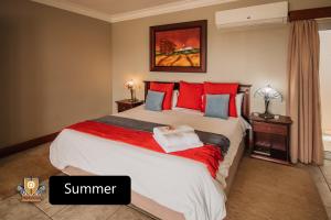 een slaapkamer met een groot bed met rode kussens bij All Seasons Boutique Hotel in Pretoria