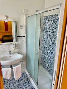 Hotel Al Rustico في Crosia: حمام مع دش ومغسلة