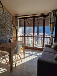 un soggiorno con tavolo in legno e divano di Home holidays- attico arc en ciel a Sestriere