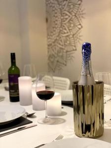 - une bouteille de vin assise sur une table avec un verre dans l'établissement Modern Town House near Oxford - 3 double bedrooms, à Witney