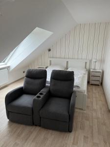 1 dormitorio con 1 cama, 1 silla y 1 sofá en Strandnahe Ferienwohnungen Duhnen inkl Fahrrädern Cuxhaven, en Cuxhaven