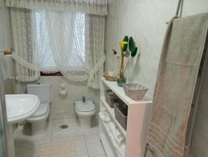 Baño blanco con aseo y lavamanos en MAR AVILLA ESPECTACULAR RIA DE VIGO con PARKING PLAYA, en Moaña