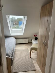 ein Schlafzimmer mit einem Fenster, einem Bett und einer Tür in der Unterkunft Strandnahe Ferienwohnungen Duhnen inkl Fahrrädern Cuxhaven in Cuxhaven