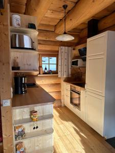 eine Küche mit weißen Schränken und einer Holzdecke in der Unterkunft Almhaus Heidi Nockberge in Patergassen