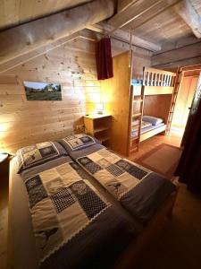 a bedroom with a bed and a bunk bed at Almhaus Heidi Nockberge in Patergassen