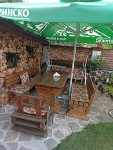 Petar Guest House في بانسكو: طاولة وكراسي ومظلة على الفناء