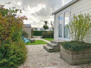 a garden with a house and a patio at Chalet 538 op Recreatiepark De Wielen in Sint Maarten