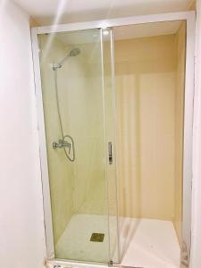 a shower with a glass door in a bathroom at Hostel Baqueira - Refugi Rosta - PyrenMuseu in Salardú