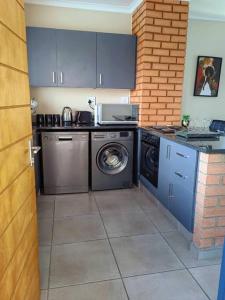 a kitchen with a washing machine and a washer at Modern 2 bedroom at Waterfall Ridge-Midrand in Midrand