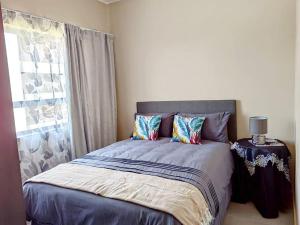 A bed or beds in a room at Modern 2 bedroom at Waterfall Ridge-Midrand