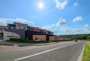 an empty street with a building on the side of a road at Modern 2 bedroom at Waterfall Ridge-Midrand in Midrand