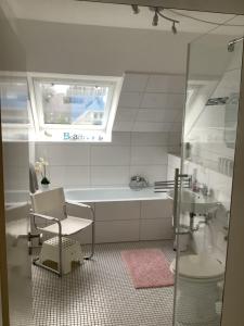 a bathroom with a bath tub and a sink at Strandnahe Ferienwohnungen Duhnen inkl Fahrrädern Cuxhaven in Cuxhaven
