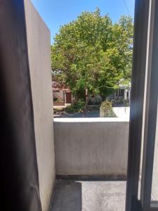 una vista desde una puerta mirando hacia un árbol en Complejo JuanXXIII en Godoy Cruz