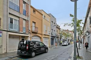 un pequeño coche negro aparcado en una calle de la ciudad en Alcam Badalona Roger 2 en Badalona