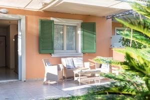 un patio con persianas verdes, mesa y sillas en Rta la Pergola, en Marina di Massa