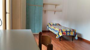ムラヴェーラにあるAppartamento Panoramaのテーブルと毛布付きのベッドが備わる客室です。