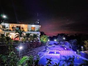 um edifício à noite com uma piscina em frente em Casa de Robles Tanay Rizal em Tanay