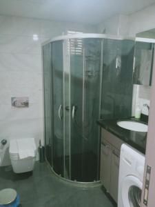 a bathroom with a shower and a toilet and a sink at Апартаменты с бассейном район хурма in Hurmaköy