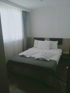 a bedroom with a bed with white sheets and pillows at Апартаменты с бассейном район хурма in Hurmaköy