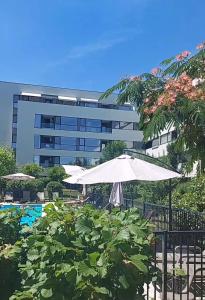 - un bâtiment avec un parasol et une piscine dans l'établissement Atria Urban Resort, à Bucarest