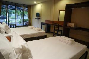 a hotel room with two beds and a mirror at The Green Koh Phangan in Haad Rin