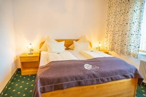 a bedroom with a large bed with a purple blanket at Pension Südhang in Bad Kleinkirchheim