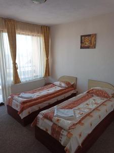 a hotel room with two beds and a window at Petar Guest House in Bansko