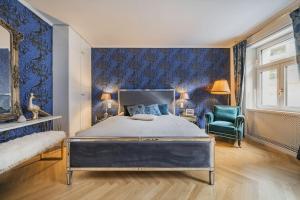1 dormitorio con cama y pared azul en Schubert's Creative Luxury Haven en Viena