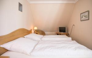 - une chambre avec un lit blanc et une télévision dans l'établissement "Appartementhaus Meeresbucht" Appartementhaus Meeresbucht Whg 8, à Büsum