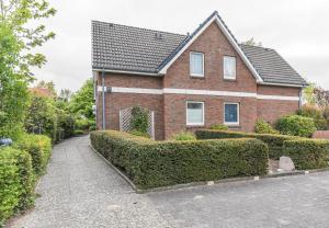 a brick house with hedges in front of it at "Ferienwohnug Bambergers" Ferienwohnung Bamberger s in Büsumer Deichhausen