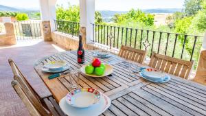 a wooden table with a bottle of wine and fruit on it at Chalet Algar by Ruralidays in Algar