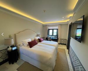 a bedroom with a large white bed in a room at Soho Boutique Castillo de Santa Catalina - Adults Recommended in Málaga