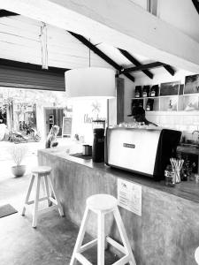 a kitchen with two stools and a counter with a person at Una Beach Hotel & OLU Cafe in Unawatuna