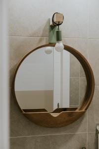 espejo redondo en la pared del baño en Natural Stay Apartamentos PassivHaus, en Logroño