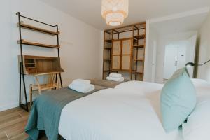 1 dormitorio con cama blanca y estante para libros en Natural Stay Apartamentos PassivHaus, en Logroño