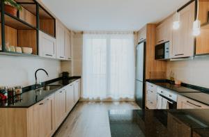 a kitchen with black counter tops and wooden cabinets at Natural Stay Apartamentos in Logroño