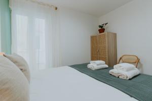 a bedroom with a bed with towels on it at Natural Stay Apartamentos in Logroño +125 photos
